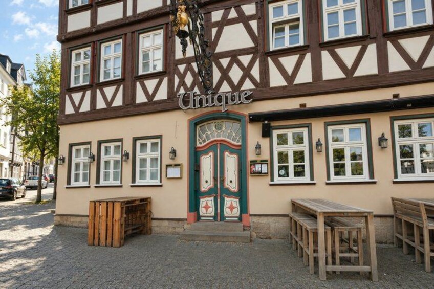 A half-timbered building with a sign reading 'Unique.' 2
