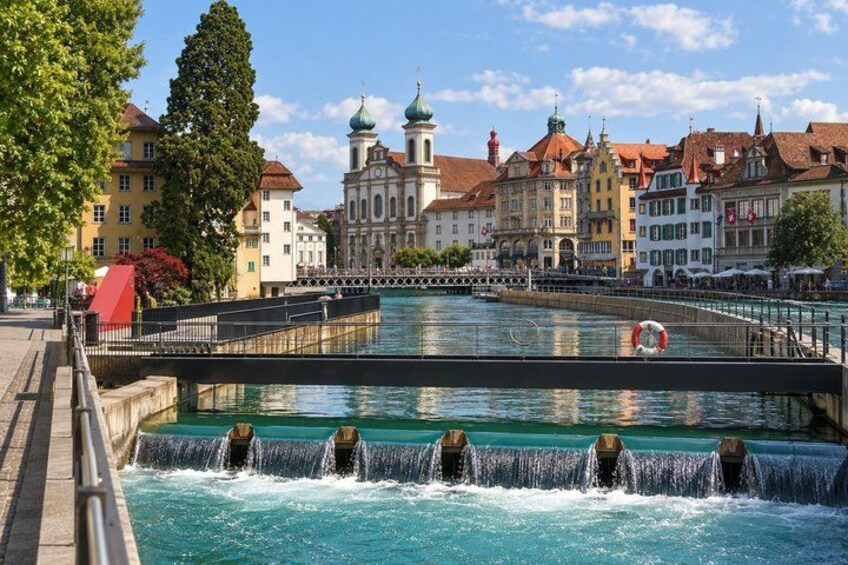 A river with a bridge, historic buildings, and a fountain. 4