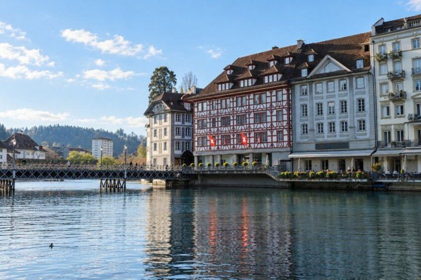 A riverside town with historic buildings, a bridge, and a calm water body. 3
