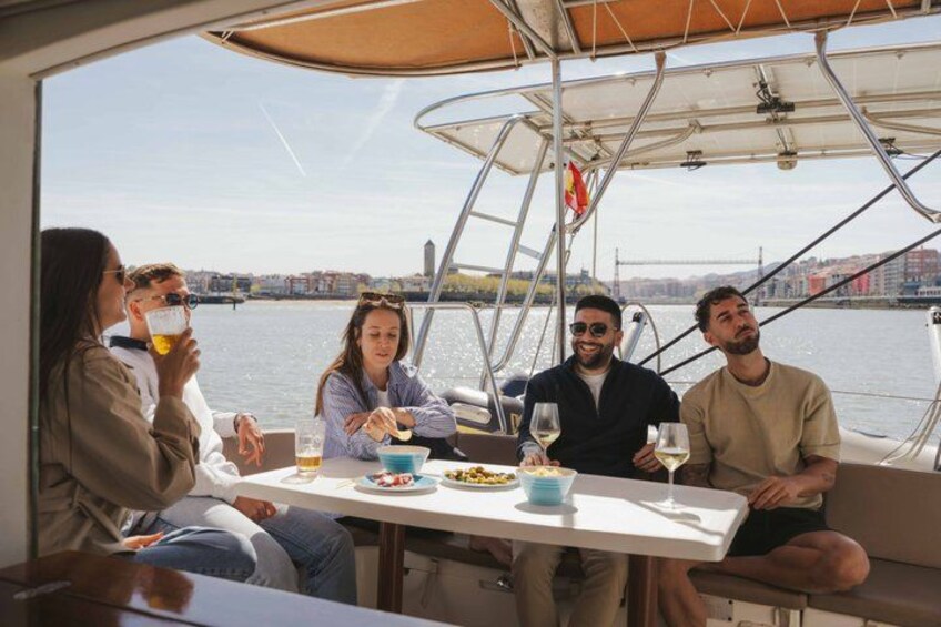 A group of people dining on a boat with a cityscape in the background. 3