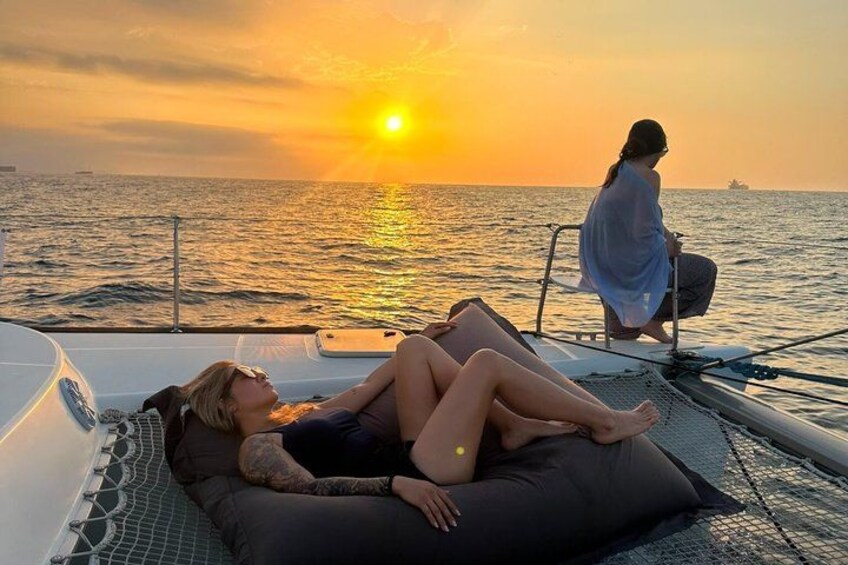 Two people relaxing on a boat at sunset. 2