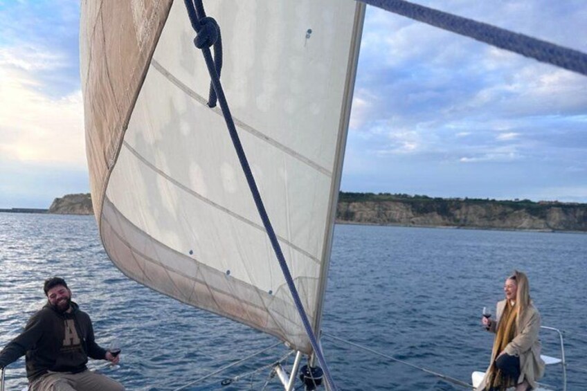A sailboat on calm waters with a clear sky and distant land. 4