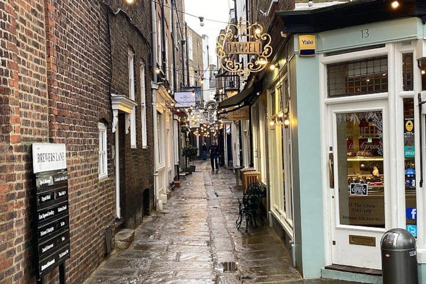 A narrow street with brick buildings, a sign for 'Brewers Lane', and a shop with a 'Yale' sign. 5