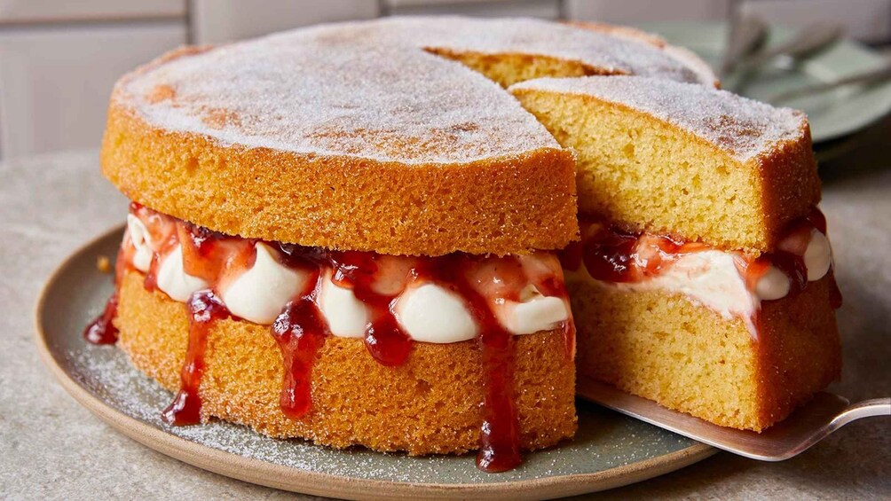 A slice of sponge cake with cream and jam. 1