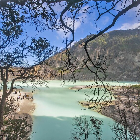 Un paisaje montañoso con un lago turquesa rodeado de acantilados rocosos y vegetación escasa. 1