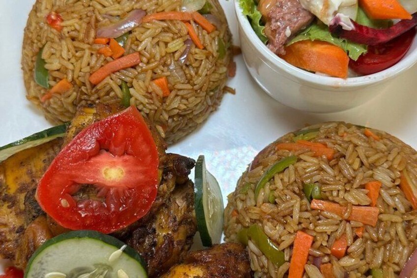 A plate of fried rice with vegetables and a slice of tomato. 1