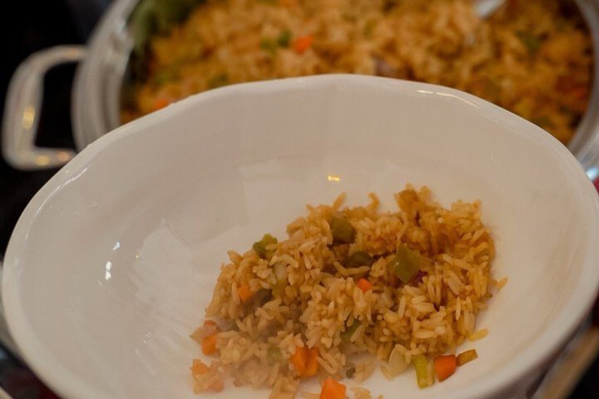 A white bowl of fried rice with vegetables. 5