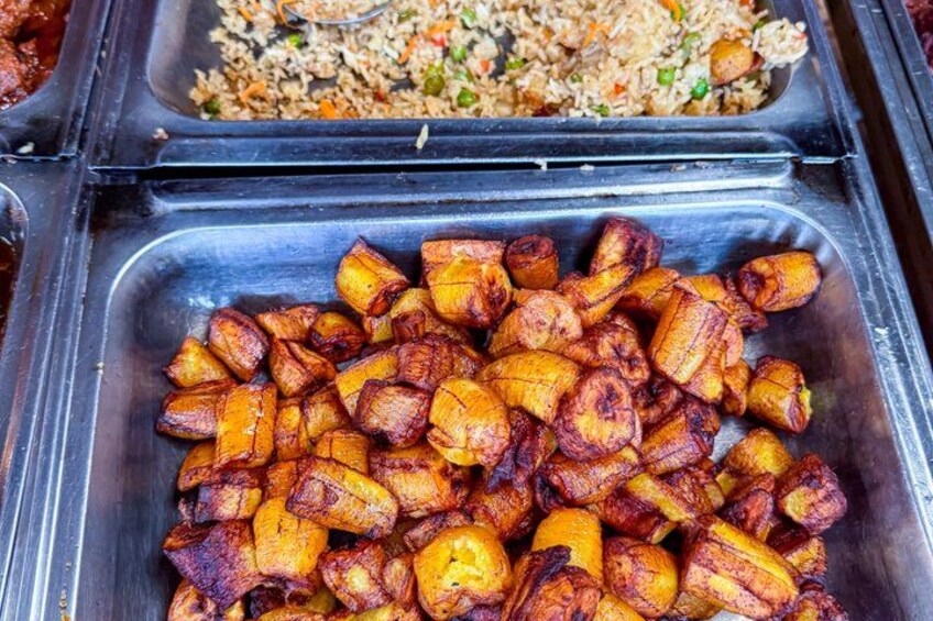 A buffet with fried plantains and a rice dish. 2