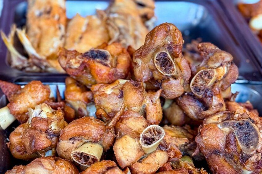 A pile of roasted chicken pieces with visible herbs and spices. 3
