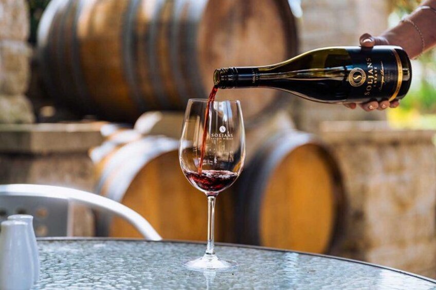 A bottle of wine being poured into a glass. 4