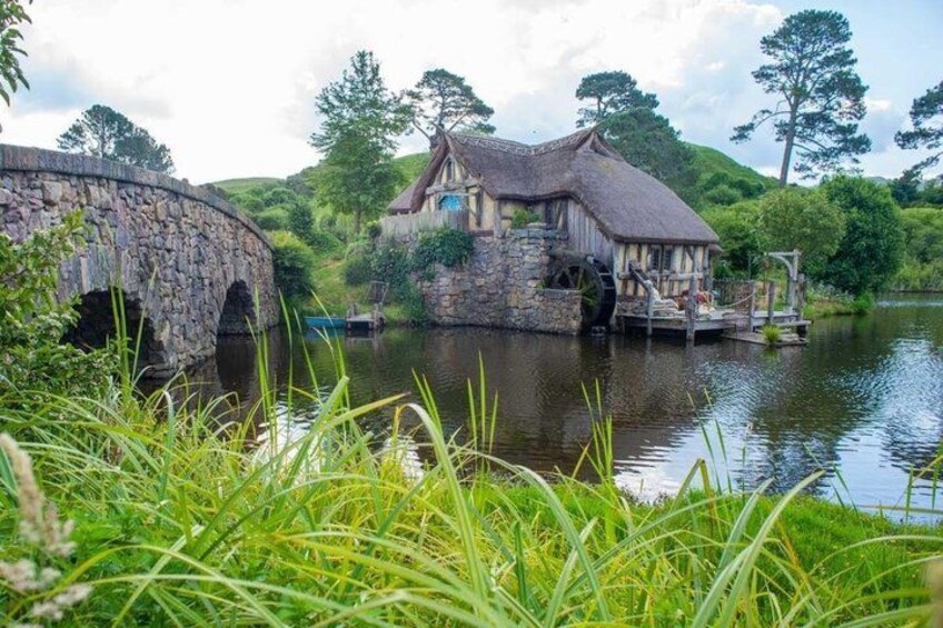 A stone bridge, a thatched-roof house, and a river. 3