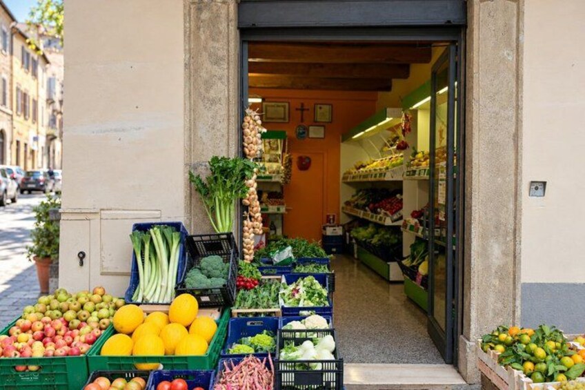 A market with fresh produce displayed outside a shop. 5