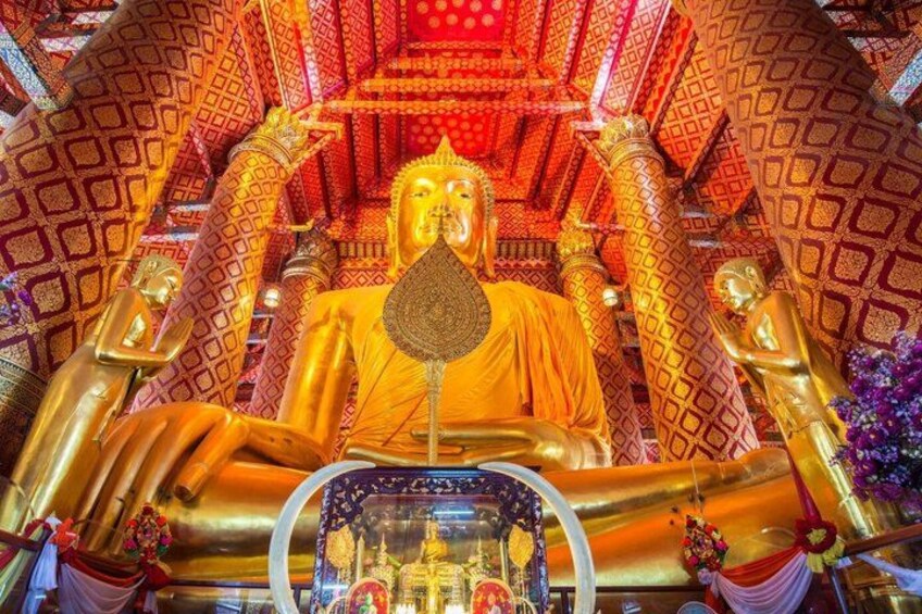 A golden statue of Buddha in a richly decorated temple interior. 3