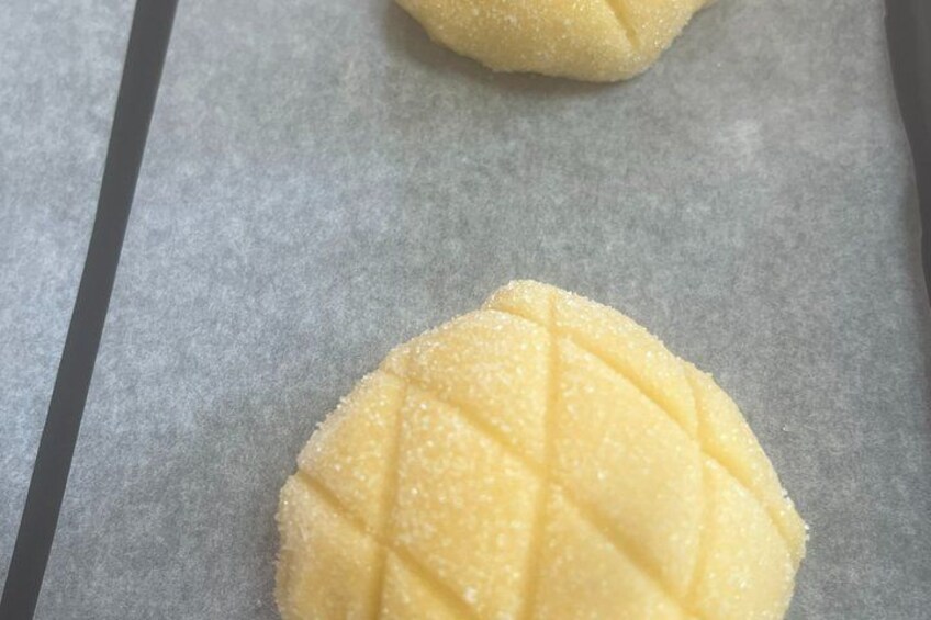 Two sugar-dusted cookies on parchment paper. 4