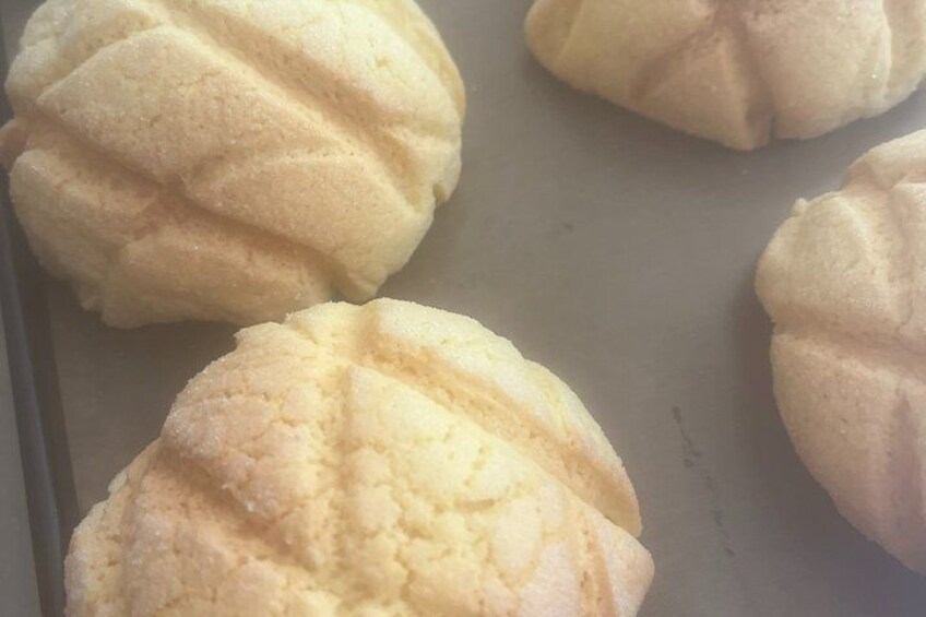 Three round, pale-colored pastries on a baking sheet. 3