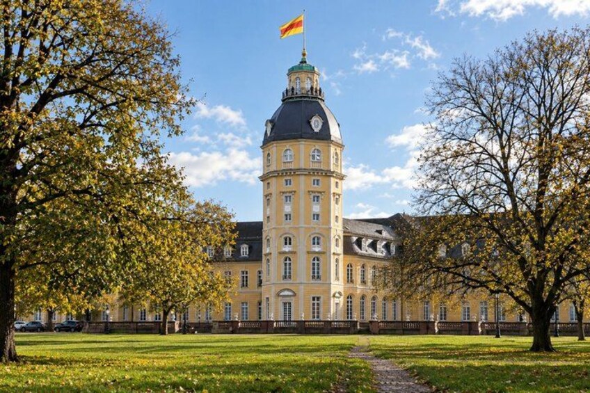 A historic building with a prominent tower, surrounded by a well-maintained lawn and trees. 3