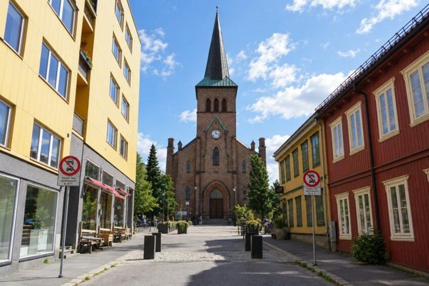 A street with buildings, a church, and no parking signs. 4