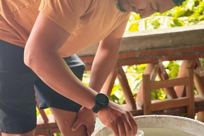 A person wearing a watch, bending over a bucket. 3