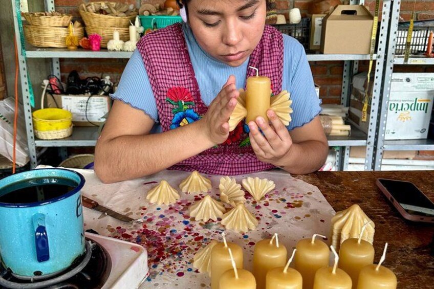 A person crafting candles with a blue container and various tools. 5
