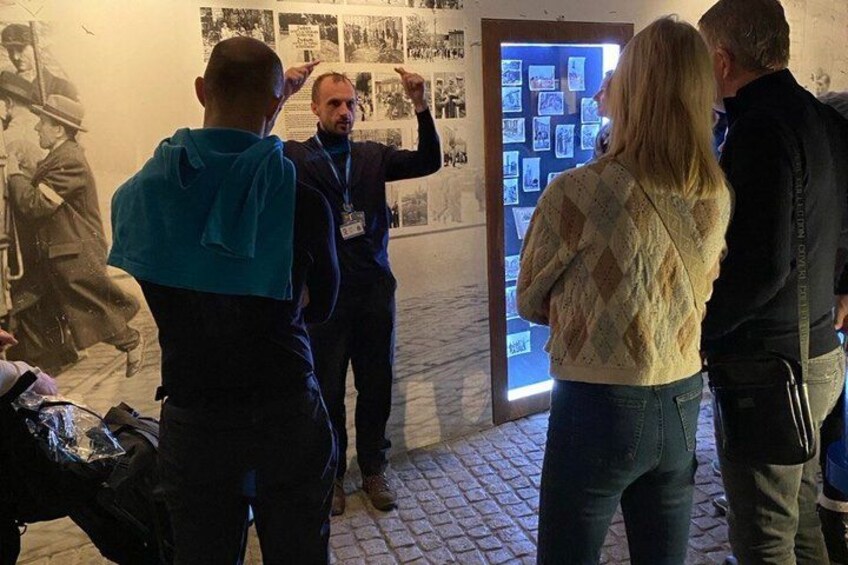 A group of people at an exhibition with photographs and informational displays. 2