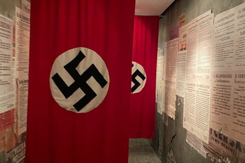 A hallway with red curtains and posters with Nazi symbols. 4