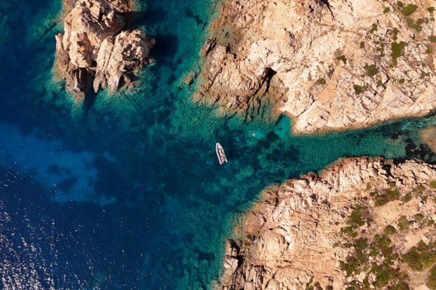 A rocky coastline with clear turquoise waters and a boat. 2