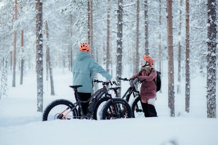 Two people with bicycles in a snowy forest. 1