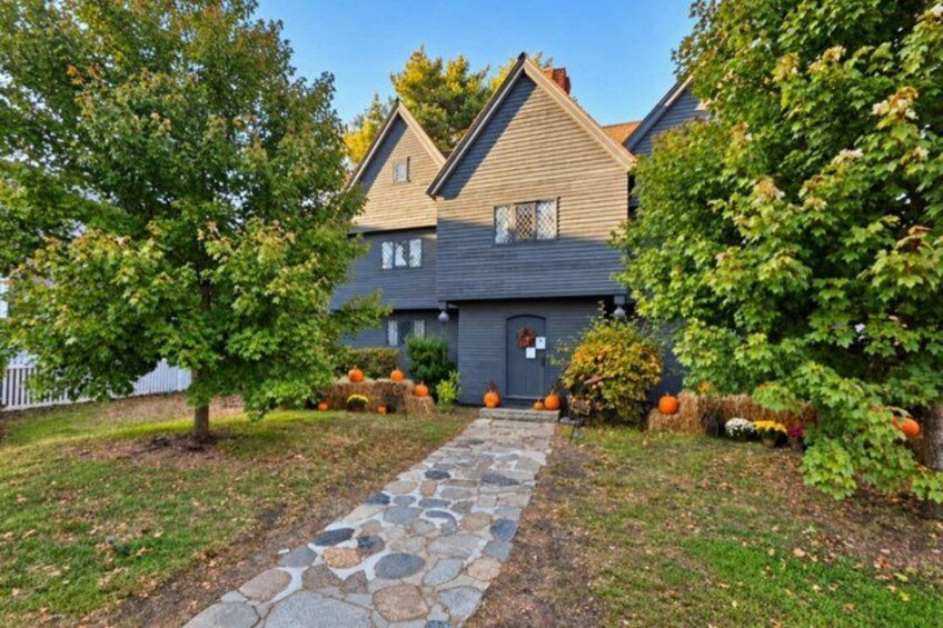 A house with a stone pathway, autumn foliage, and decorative pumpkins. 1