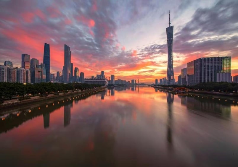 A city skyline at sunset with a river reflecting the buildings. 2