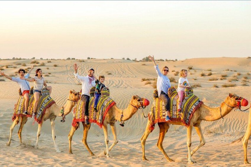 A group of people riding camels in a desert landscape. 2
