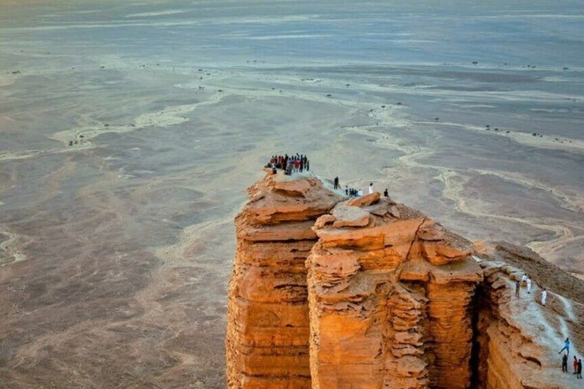 A large rock formation with people standing on top. 5