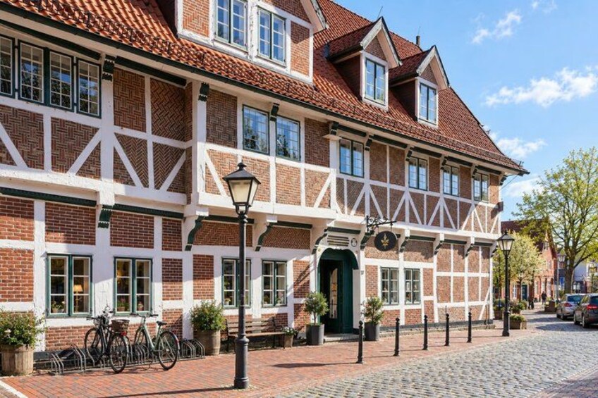 A traditional half-timbered building with a cobblestone street and bicycles parked in front. 5
