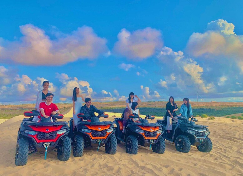 A group of people on ATVs in a desert landscape with a clear sky. 1