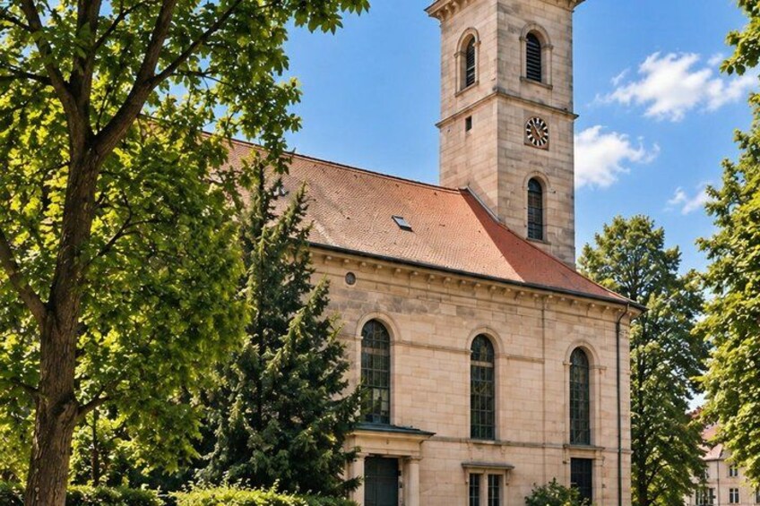 A historic building with a clock tower, arched windows, and a red roof. 5
