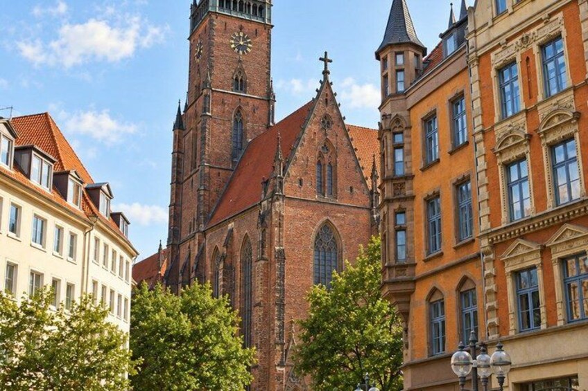 A historic church with a tall clock tower, surrounded by traditional European architecture. 5
