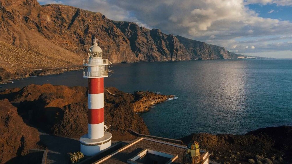 Un phare situé sur une côte rocheuse, offrant une vue dégagée sur la mer et le lointain rivage. 4