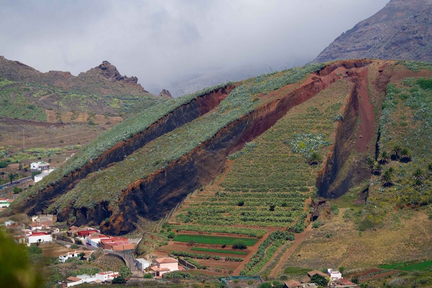 Un paysage montagneux caractérisé par des champs en terrasses et un petit village situé au pied de la montagne. 5