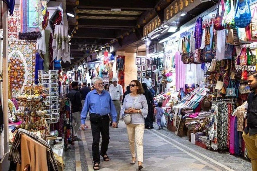 A bustling market with various stalls selling textiles and accessories. 2
