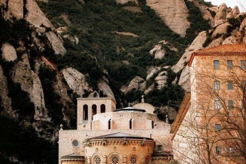 A church with a dome and bell tower, surrounded by rocky terrain and vegetation. 2