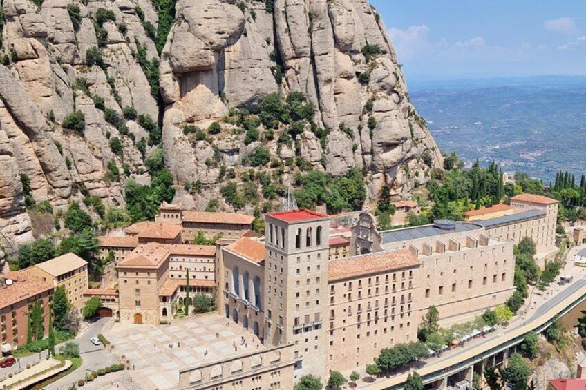A town with historic buildings, a large rock formation, and a road. 1