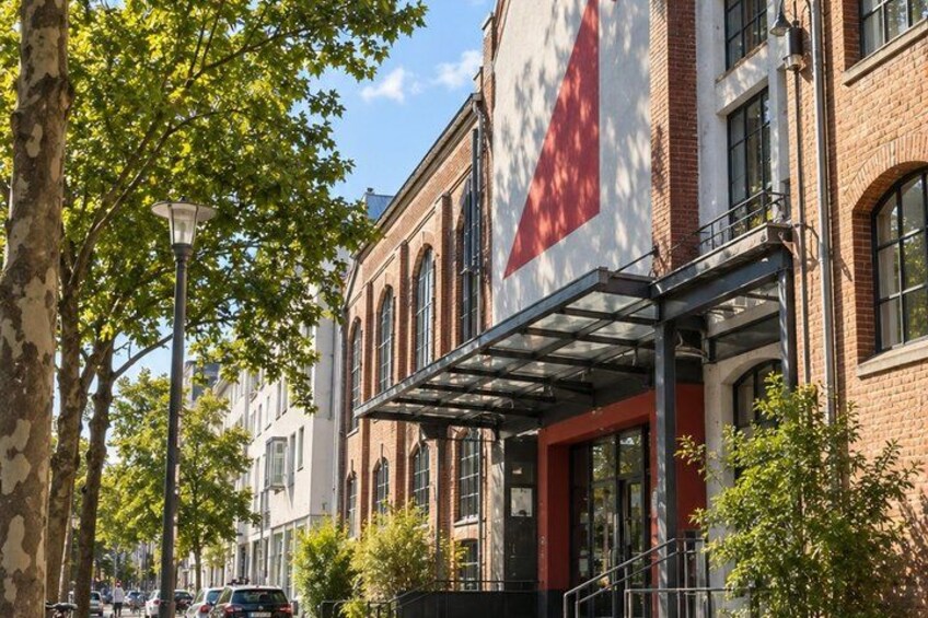 A street with brick buildings, a covered entrance, and trees. 3