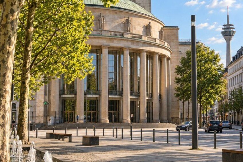 A classical building with columns, a fountain, and a tower in the background. 5