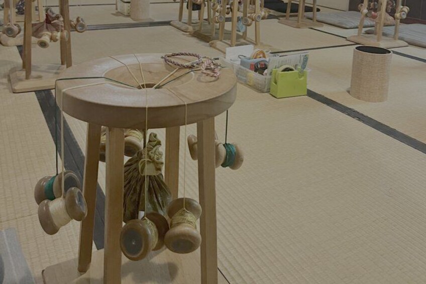 A tatami mat room with a central wooden table holding several spinning tops. 5