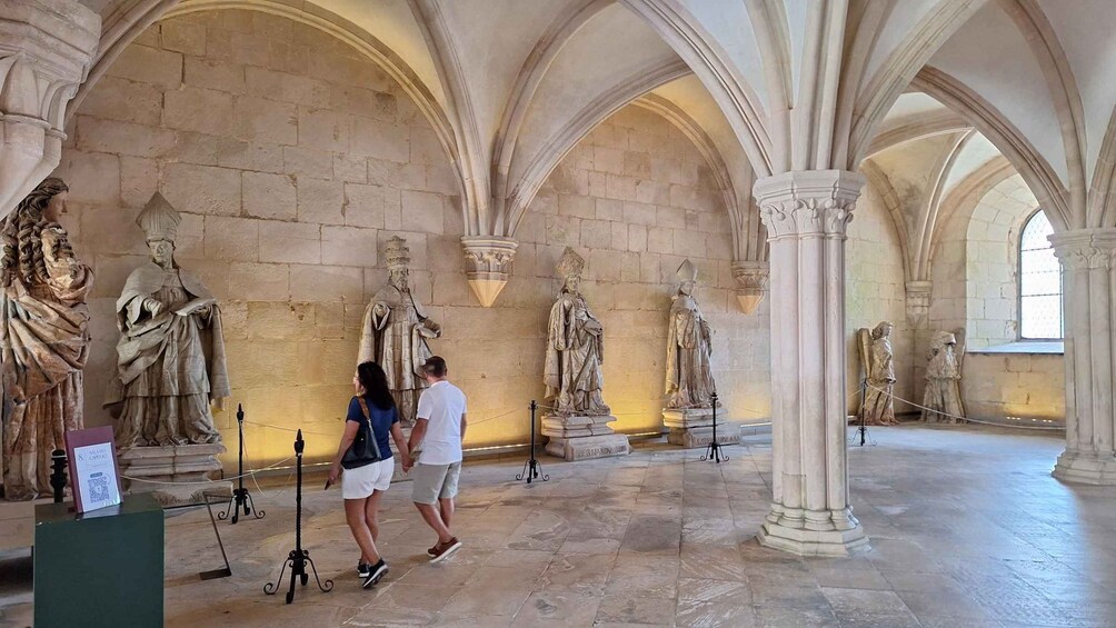 Un edificio histórico con techos abovedados y estatuas a lo largo de las paredes. 5