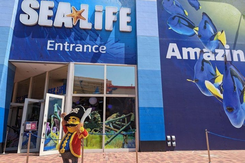 The entrance to SeaLife with a large aquarium mural and a mascot. 2