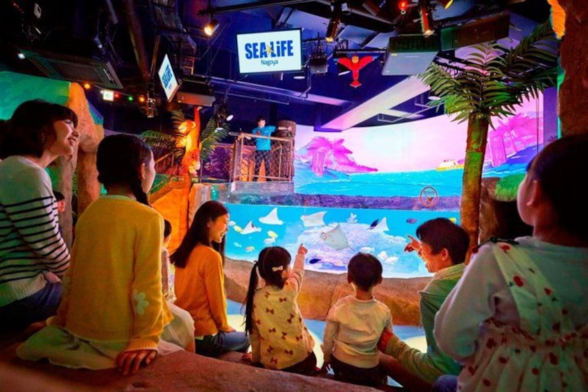 An indoor aquarium with a large display of marine life, including fish and sea turtles, and a sign that reads 'SEA LIFE.' 5