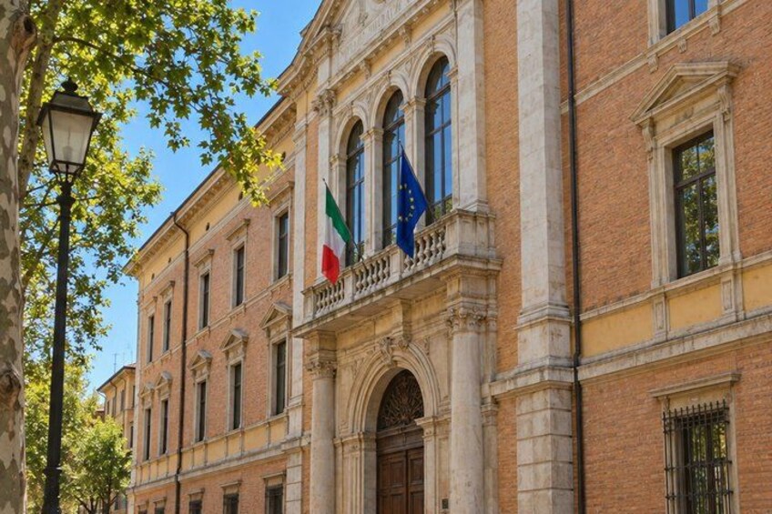 A historic building with a classical facade, flags, and a street lamp. 4