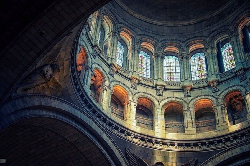 A grand architectural interior with arched ceilings, stained glass windows, and classical sculptures. 2