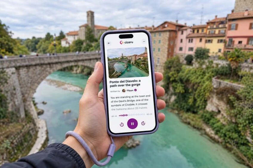 A hand holding a smartphone displaying a travel article about Ponte del Diavolo. 1