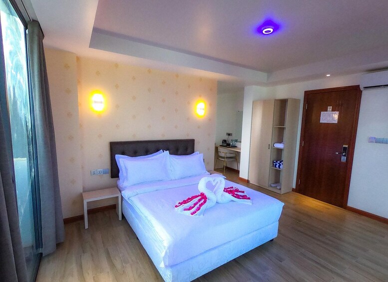 Une chambre d’hôtel comprenant un lit, des tables de chevet, un bureau, une armoire et une salle de bain. 5